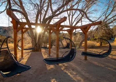 Outdoor swings near a glamping site during sunset.